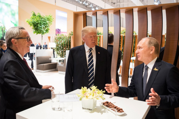 Donald Trump, Präsident der Vereinigten Staaten von Amerika, im Gespräch mit dem russischen Präsidenten Wladimir Putin am Rande des Retreats. Links: EU-Kommissionspräsident Juncker.