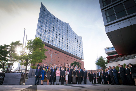 Family photo of the G20 leaders and their partners in front of the Elbphilharmonie Concert Hall. 